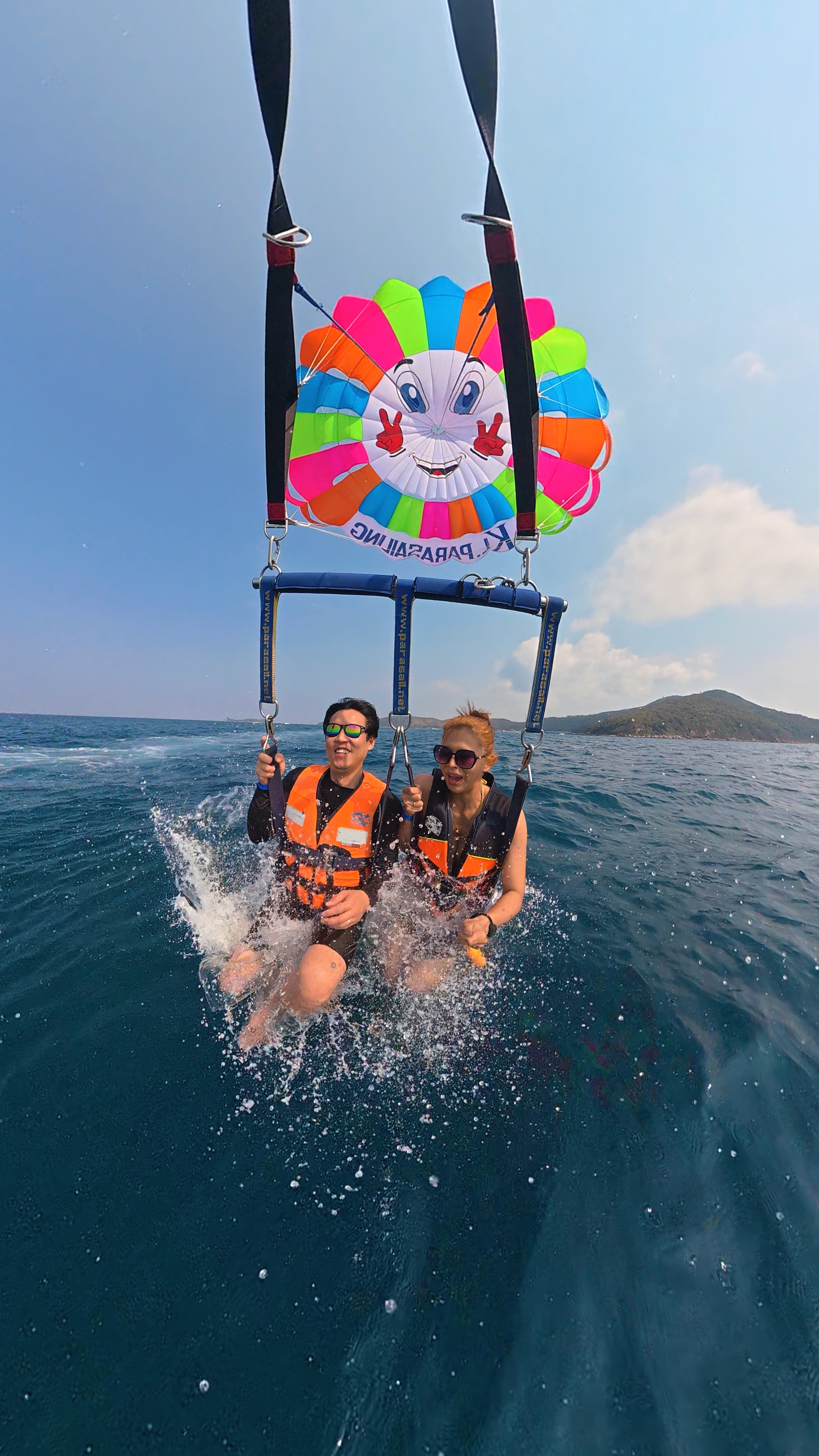 Two people parasailing close to the beach
